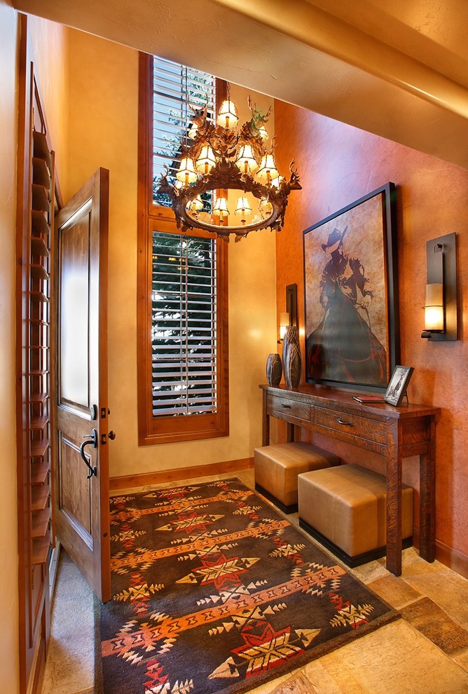 This is an example of a mid-sized foyer in Salt Lake City with yellow walls, travertine floors, a single front door and a medium wood front door.