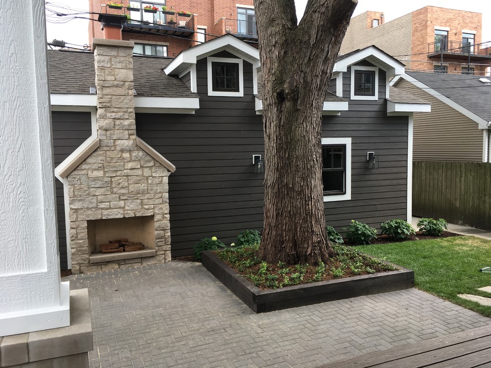 Inspiration for a large transitional backyard home design remodel in Chicago with a roof extension