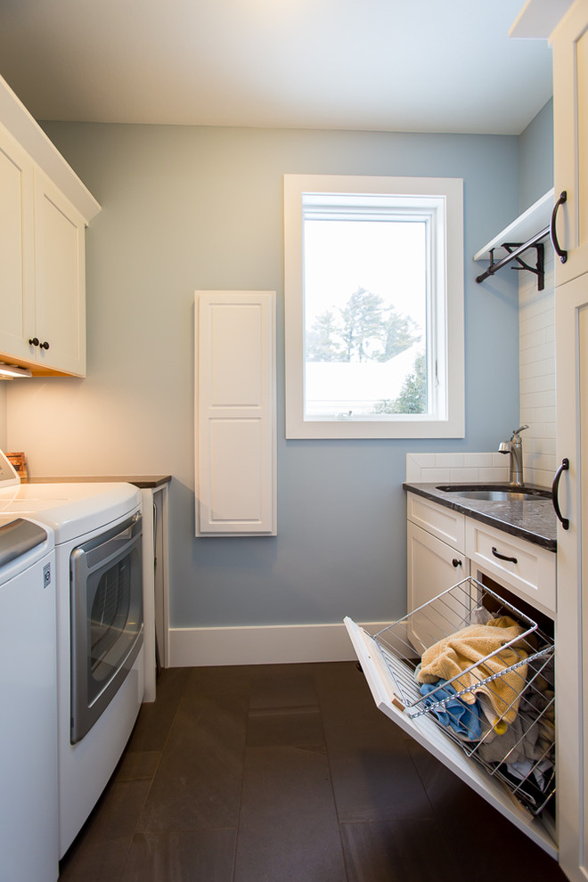 Example of a small beach style galley ceramic tile and brown floor dedicated laundry room design with an undermount sink, shaker cabinets, white cabinets, granite countertops, blue walls and a side-by-side washer/dryer