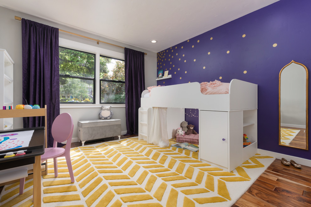 Edgewood - Fairy Tail Bedrooms - Fun, royal-themed girl's bedroom featuring loft bed with secret reading nook, art station, dress-up mirror, golden rug, custom purple drapes, and purple and gray walls. Photo by Exceptional Frames.