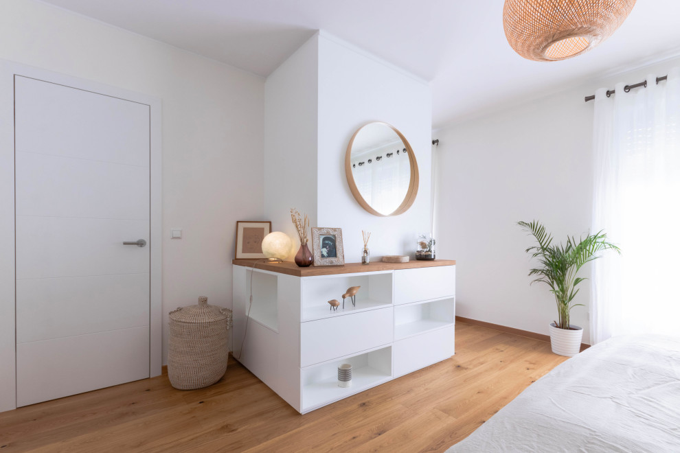 Großes Skandinavisches Hauptschlafzimmer mit weißer Wandfarbe, braunem Holzboden und braunem Boden in Sonstige
