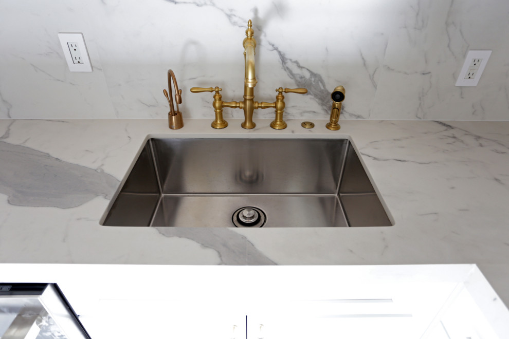 Mid-sized transitional l-shaped marble floor, white floor and exposed beam kitchen photo in DC Metro with an undermount sink, shaker cabinets, white cabinets, quartzite countertops, white backsplash, quartz backsplash and stainless steel appliances