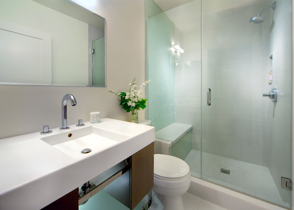 Mid-sized contemporary 3/4 wet room bathroom in Other with flat-panel cabinets, dark wood cabinets, beige tile, glass tile, beige walls, porcelain floors, an integrated sink, solid surface benchtops, beige floor, a hinged shower door and white benchtops.