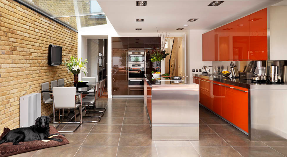 Inspiration for a contemporary eat-in kitchen in London with flat-panel cabinets, stainless steel benchtops, porcelain floors and with island.