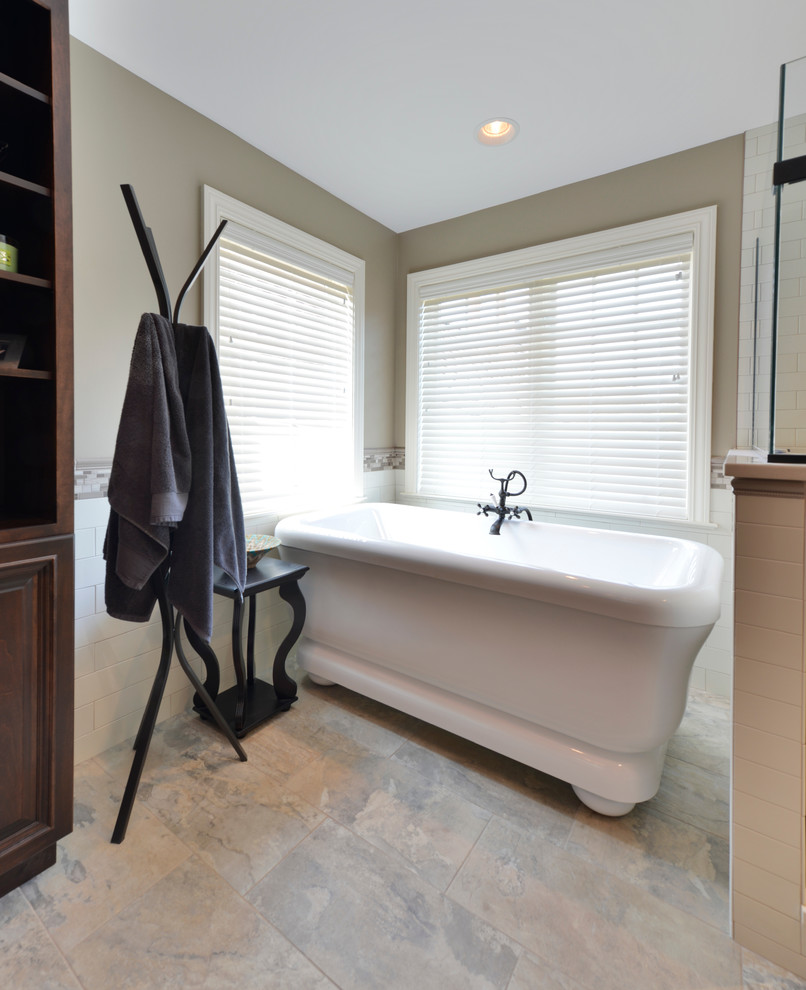 This is an example of a large transitional master bathroom in Other with an undermount sink, beaded inset cabinets, dark wood cabinets, quartzite benchtops, a freestanding tub, an alcove shower, a two-piece toilet, multi-coloured tile, glass sheet wall, beige walls and porcelain floors.