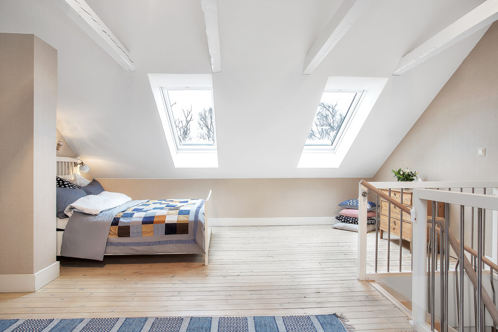 Mid-sized transitional loft-style bedroom in Stockholm with beige walls, light hardwood floors and no fireplace.