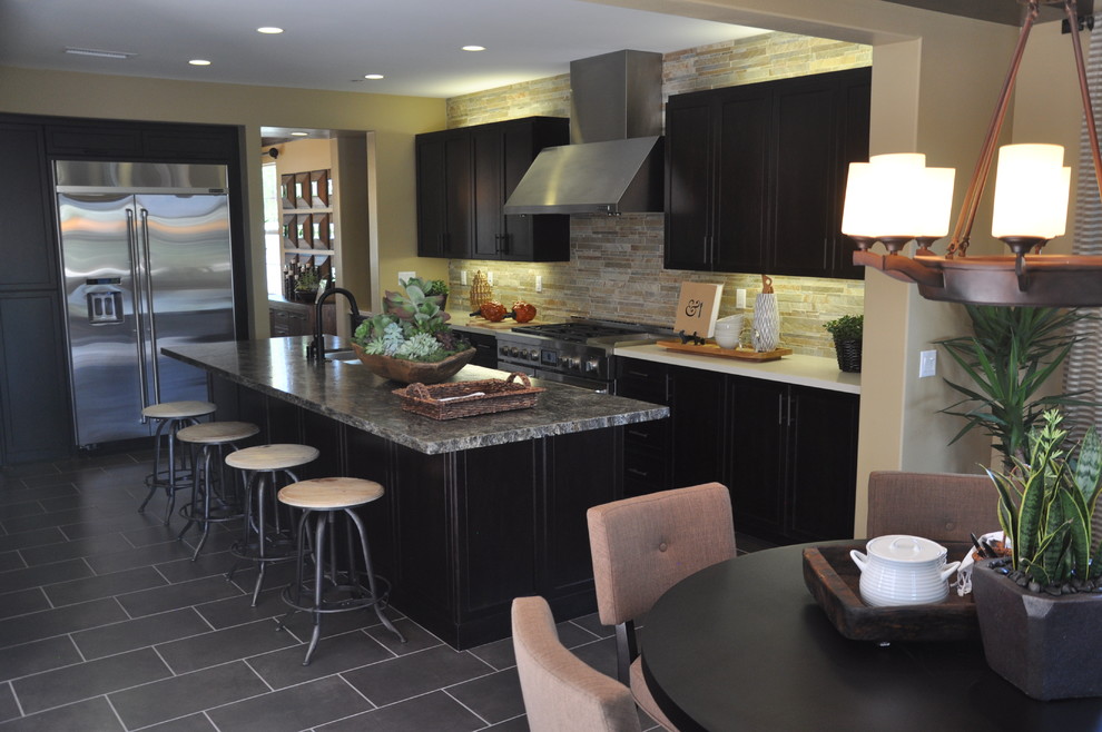 Mid-sized contemporary l-shaped open plan kitchen in Los Angeles with an undermount sink, shaker cabinets, dark wood cabinets, granite benchtops, stone tile splashback, stainless steel appliances, porcelain floors and with island.