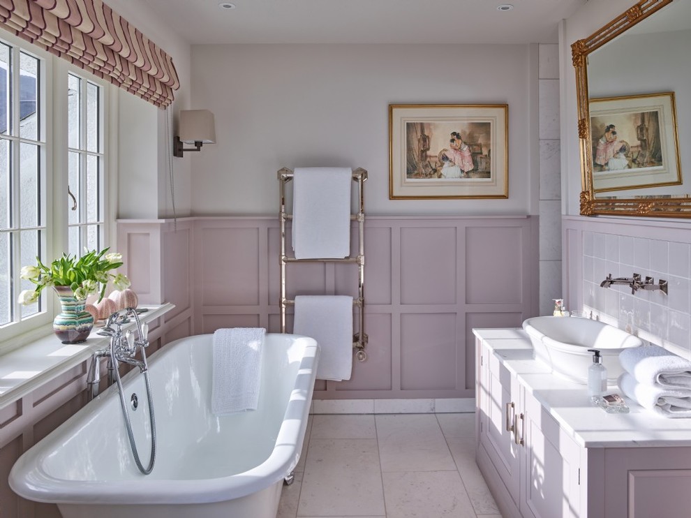 Inspiration for a mid-sized traditional master bathroom in Other with raised-panel cabinets, purple cabinets, a freestanding tub, pink tile, beige walls, a vessel sink, beige floor and white benchtops.