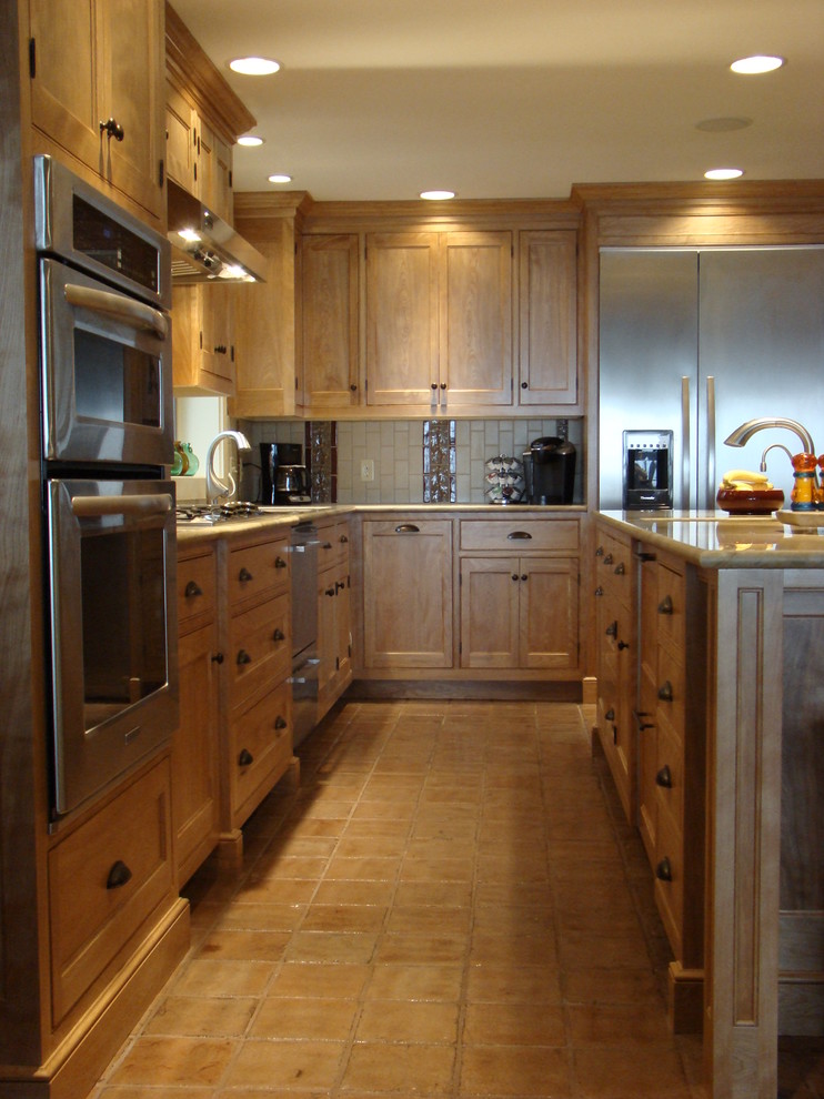 This is an example of a mid-sized contemporary l-shaped separate kitchen in Portland Maine with an undermount sink, beaded inset cabinets, medium wood cabinets, granite benchtops, multi-coloured splashback, ceramic splashback, stainless steel appliances, ceramic floors and with island.