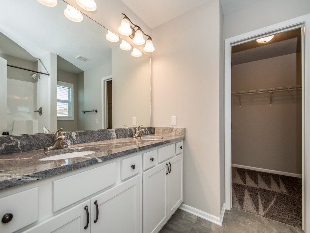 Large transitional master ceramic tile and gray floor alcove shower photo with shaker cabinets, white cabinets, a two-piece toilet, beige walls, an undermount sink, granite countertops and multicolored countertops