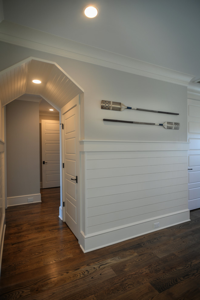 Inspiration for a mid-sized beach style hallway in Charleston with white walls, dark hardwood floors and brown floor.