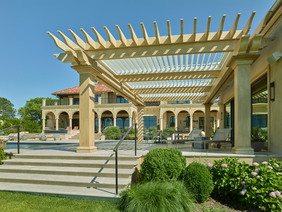This is an example of a mediterranean backyard patio in Dallas with tile and a pergola.