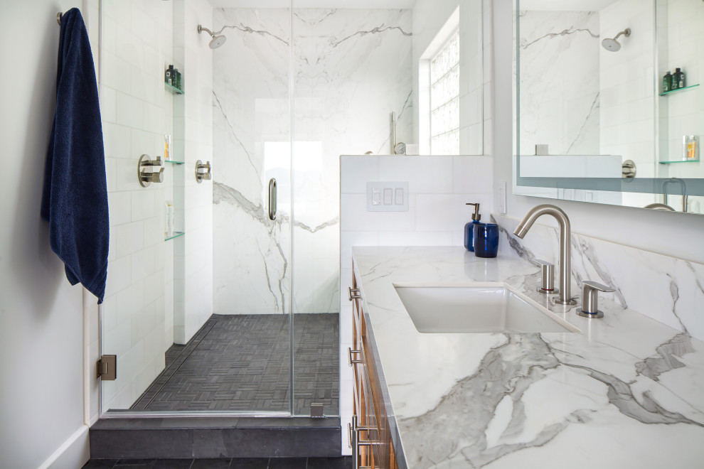 This is an example of a large midcentury master bathroom in Los Angeles with shaker cabinets, medium wood cabinets, a double shower, a bidet, white tile, marble, white walls, slate floors, an undermount sink, solid surface benchtops, black floor, a hinged shower door, white benchtops, an enclosed toilet, a double vanity and a built-in vanity.