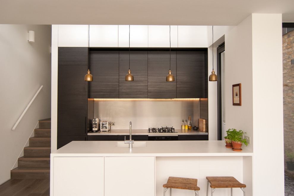 This is an example of a contemporary kitchen in London with an integrated sink and a peninsula.