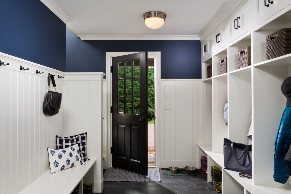 Photo of a large traditional mudroom in Boston with blue walls, slate floors, a single front door, a black front door, black floor and planked wall panelling.