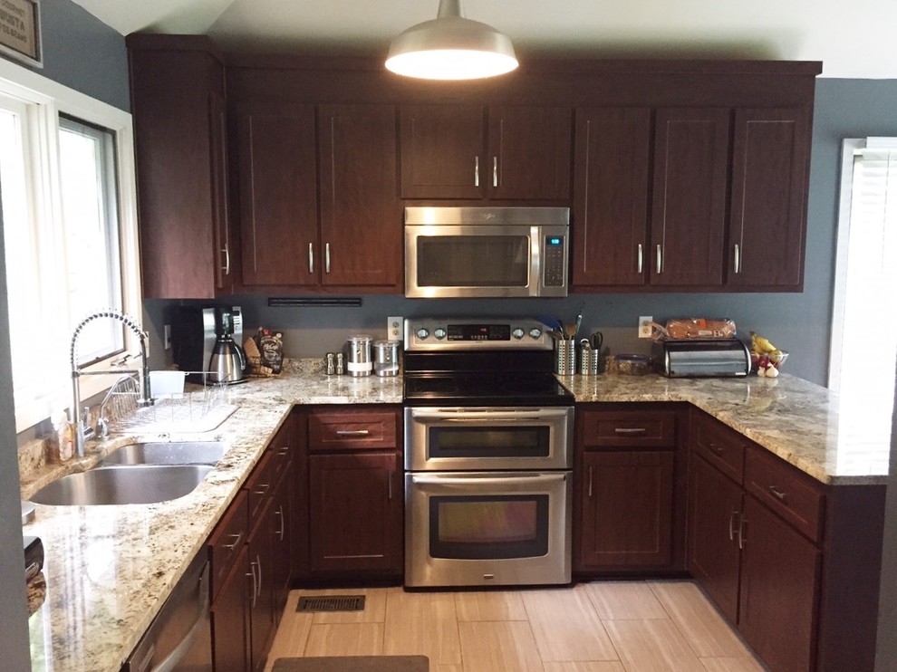 This is an example of a mid-sized contemporary u-shaped eat-in kitchen in Richmond with an undermount sink, shaker cabinets, dark wood cabinets, granite benchtops, stainless steel appliances and a peninsula.
