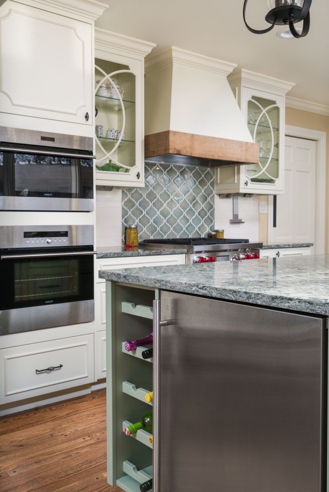 This is an example of a large country l-shaped eat-in kitchen in Columbus with an undermount sink, beaded inset cabinets, yellow cabinets, quartz benchtops, green splashback, brick splashback, stainless steel appliances, medium hardwood floors, with island, brown floor and green benchtop.