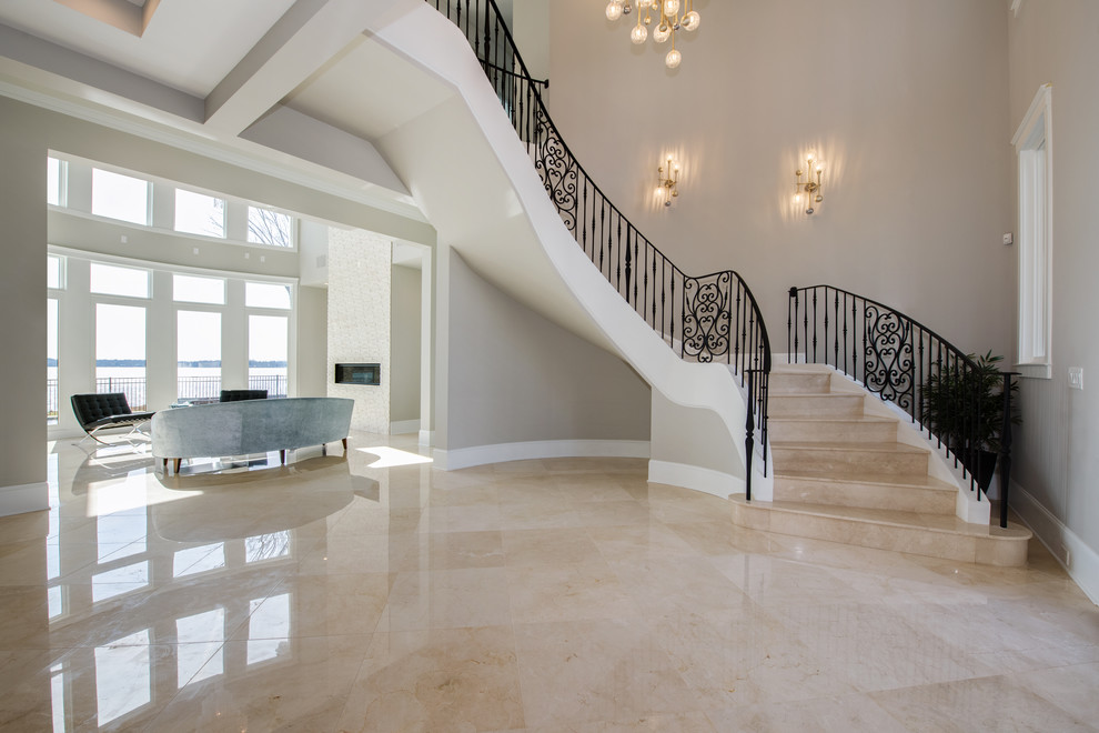 Design ideas for a large modern marble curved staircase in Charlotte with marble risers and metal railing.