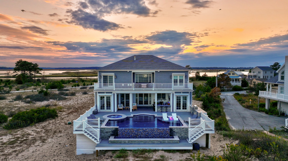 Mid-sized trendy backyard custom-shaped infinity hot tub photo with decking