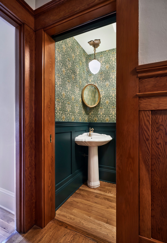 Kleine Klassische Gästetoilette mit weißen Schränken, grüner Wandfarbe, braunem Holzboden, Sockelwaschbecken, braunem Boden, freistehendem Waschtisch und Tapetenwänden in Portland