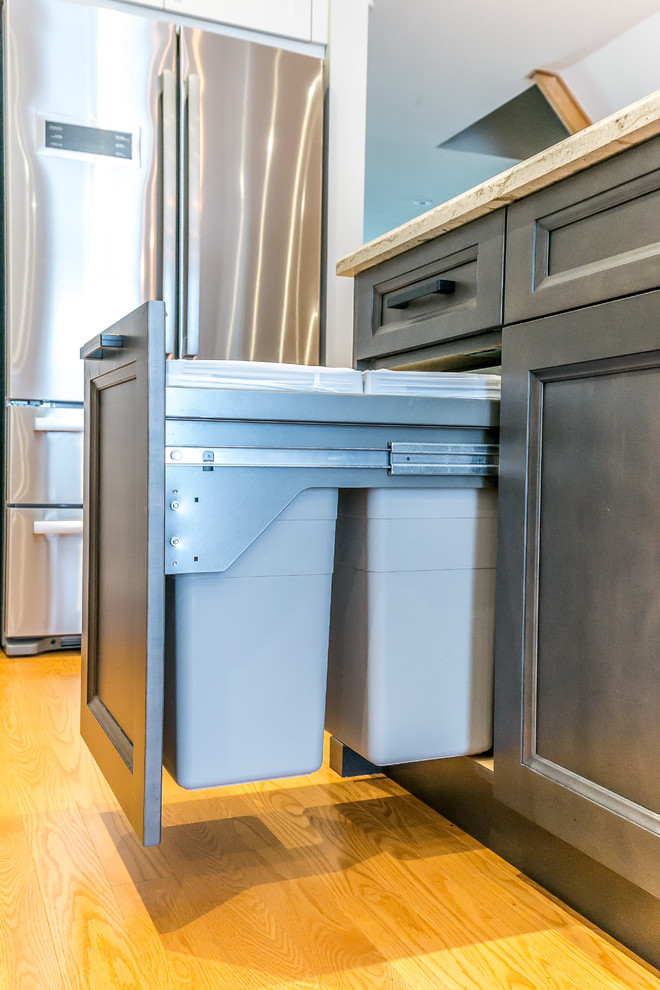Kitchen - mid-sized transitional l-shaped brown floor kitchen idea in Toronto with a double-bowl sink, white cabinets, white backsplash, stainless steel appliances and an island
