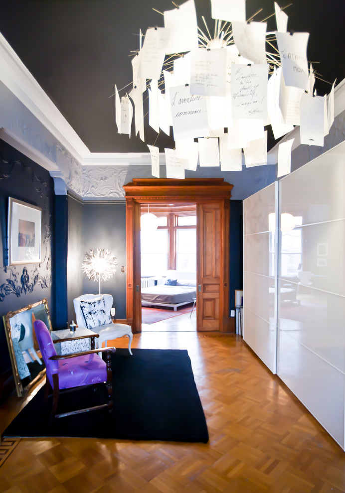 This is an example of a contemporary hallway in New York with black walls and medium hardwood floors.