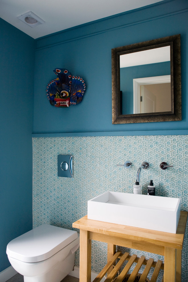 This is an example of a contemporary powder room in Other with a one-piece toilet, blue tile, white tile, matchstick tile, blue walls, a vessel sink and wood benchtops.