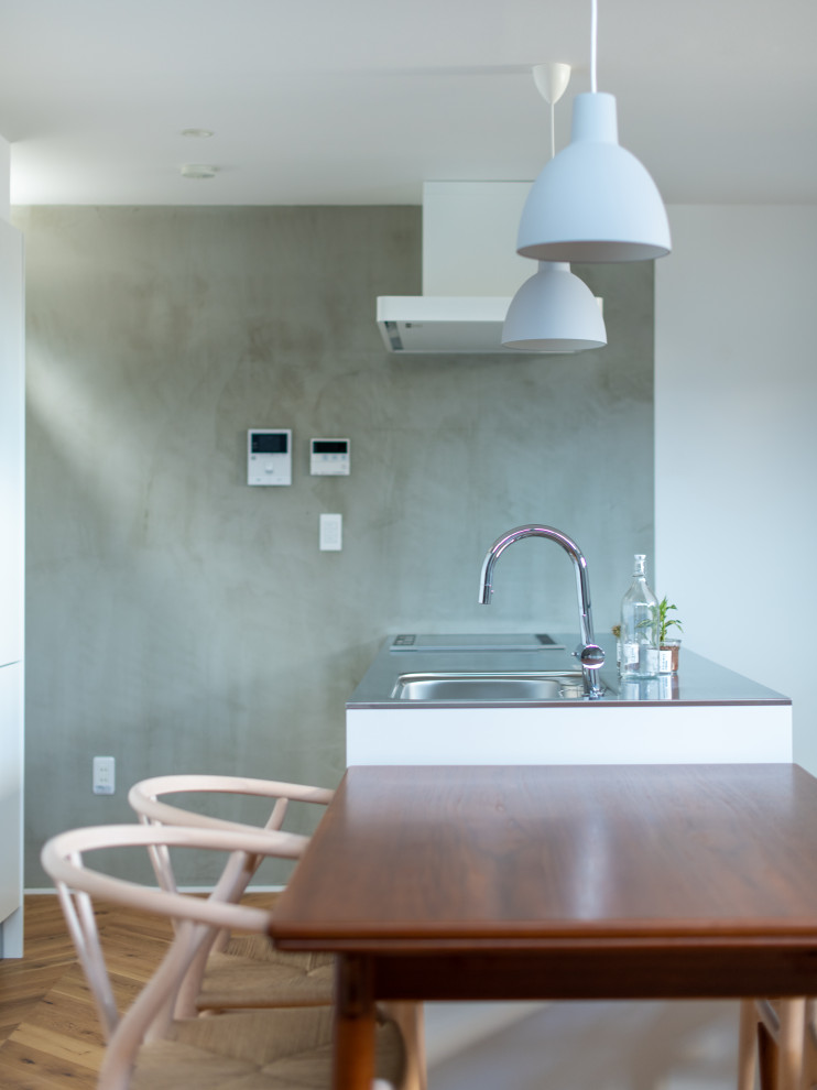 Kleines, Offenes Skandinavisches Wohnzimmer in grau-weiß ohne Kamin mit braunem Boden, Tapetendecke, Hausbar, grauer Wandfarbe, gebeiztem Holzboden und TV-Wand in Sonstige