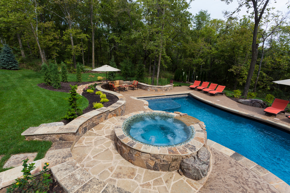 This is an example of a large arts and crafts backyard custom-shaped pool in Kansas City with a water feature and concrete slab.