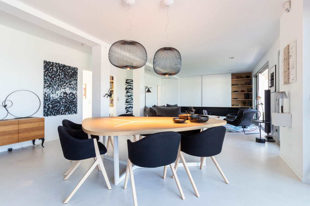 This is an example of a contemporary open plan dining in Nantes with white walls, concrete floors and white floor.