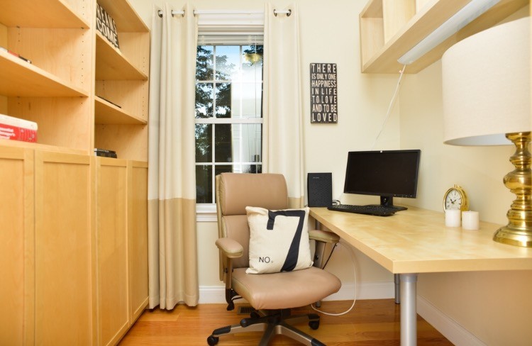 Photo of a small transitional home office in Boston with yellow walls, light hardwood floors, no fireplace, a freestanding desk and brown floor.