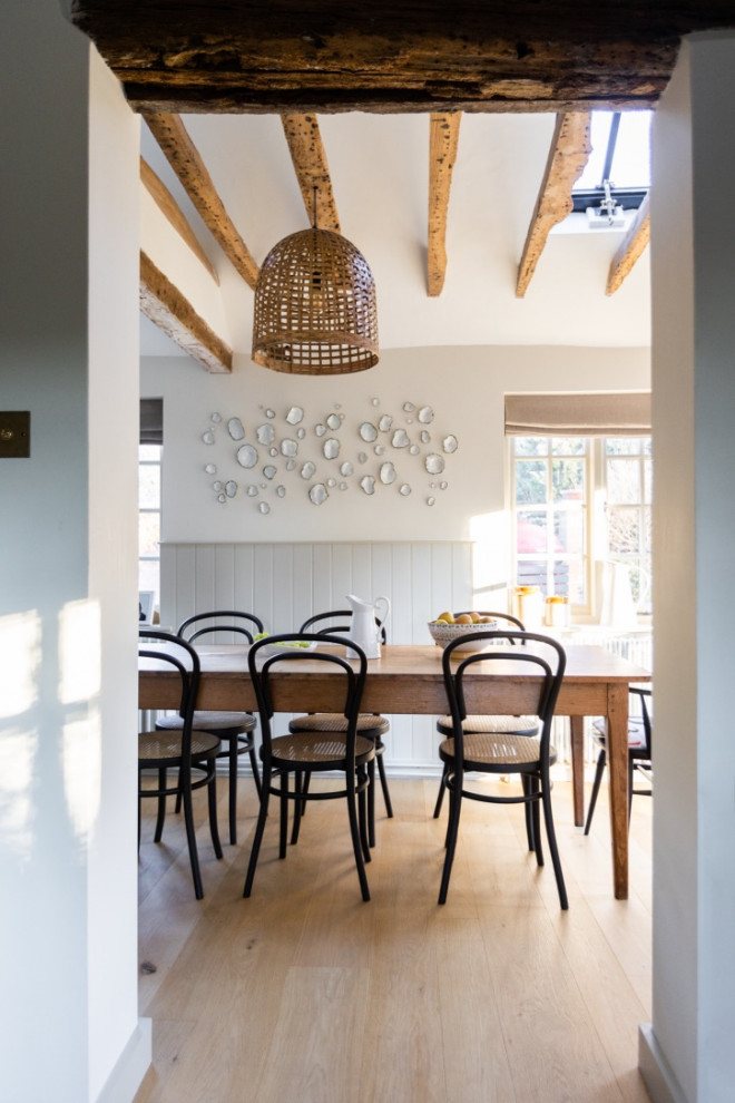 Inspiration pour une salle à manger ouverte sur la cuisine chalet de taille moyenne avec un mur blanc, sol en stratifié et boiseries.