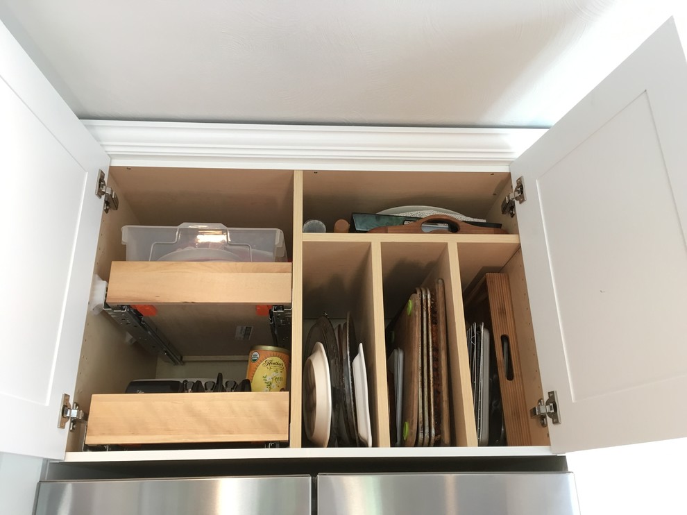 Enclosed kitchen - mid-sized transitional l-shaped light wood floor enclosed kitchen idea with an undermount sink, flat-panel cabinets, white cabinets, granite countertops, white backsplash, subway tile backsplash, stainless steel appliances and no island