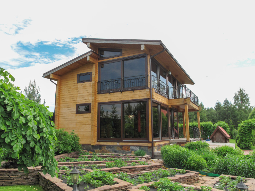 Панорамное остекление загородного дома окнами и порталами из сосны