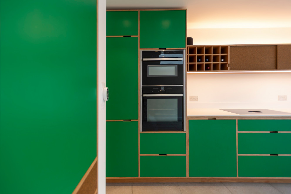 Inspiration for a medium sized scandinavian single-wall kitchen/diner in London with an integrated sink, recessed-panel cabinets, green cabinets, integrated appliances, porcelain flooring, no island, grey floors and white worktops.