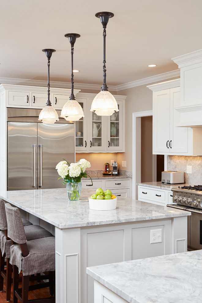 Inspiration for a beach style kitchen in Boston with a farmhouse sink, beaded inset cabinets, white cabinets, marble benchtops, white splashback, subway tile splashback, stainless steel appliances, medium hardwood floors and with island.