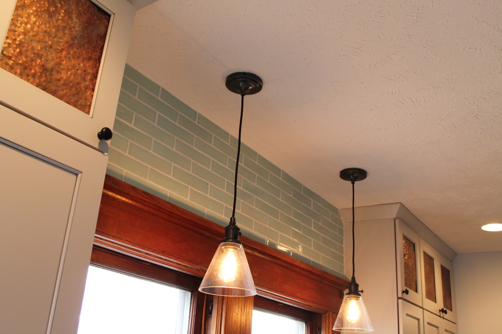Kitchen - mid-sized transitional medium tone wood floor kitchen idea with an undermount sink, shaker cabinets, white cabinets, quartz countertops, blue backsplash, subway tile backsplash and an island