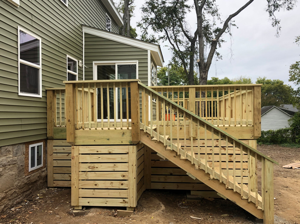 This is an example of a mid-sized backyard deck in Nashville with with skirting, no cover and wood railing.