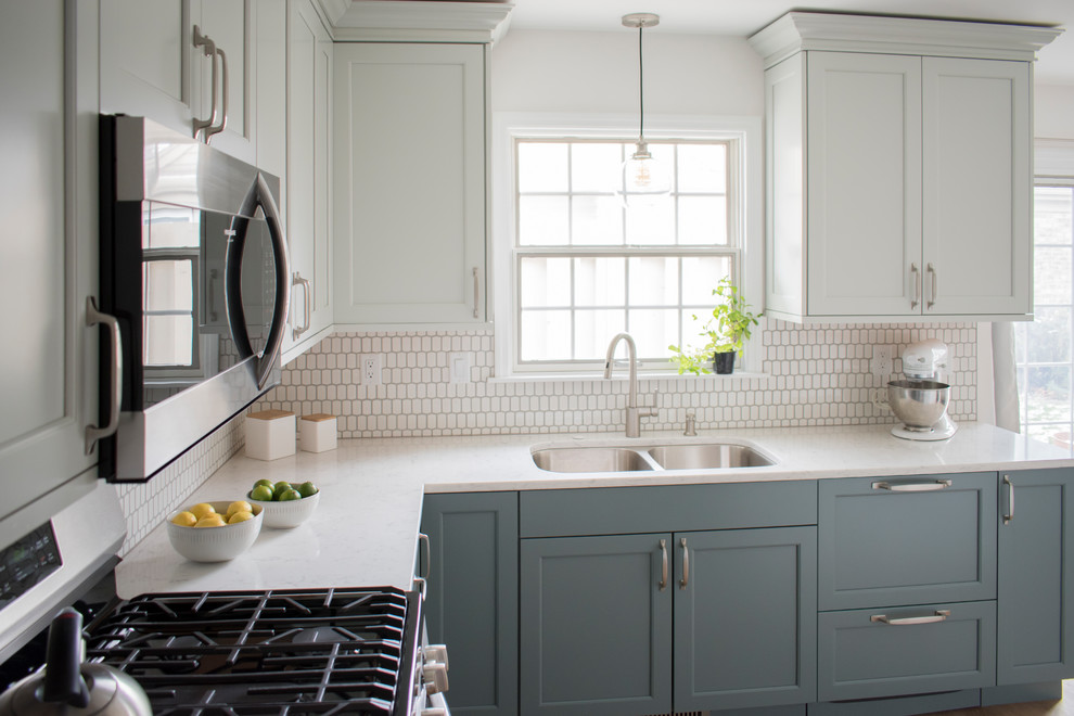 Inspiration for a mid-sized transitional l-shaped light wood floor and beige floor eat-in kitchen remodel in Chicago with an undermount sink, shaker cabinets, quartz countertops, white backsplash, mosaic tile backsplash, stainless steel appliances, no island, white countertops and blue cabinets