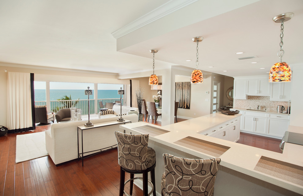 This is an example of a mid-sized transitional l-shaped eat-in kitchen in Miami with white cabinets, beige splashback, stainless steel appliances, an undermount sink, recessed-panel cabinets, wood benchtops, mosaic tile splashback, medium hardwood floors, a peninsula and brown floor.