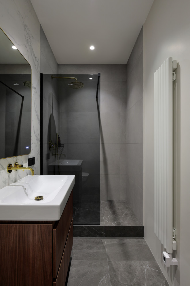 Design ideas for a mid-sized contemporary powder room in Saint Petersburg with a wall-mount toilet, flat-panel cabinets, dark wood cabinets, gray tile, porcelain tile, porcelain floors, solid surface benchtops, grey floor, white benchtops and a floating vanity.