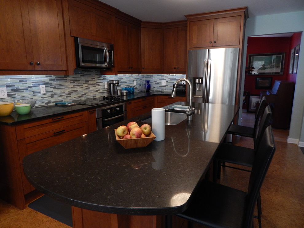 Example of a mid-sized transitional galley cork floor eat-in kitchen design with an undermount sink, shaker cabinets, medium tone wood cabinets, quartz countertops, blue backsplash, glass tile backsplash, stainless steel appliances, blue walls and an island