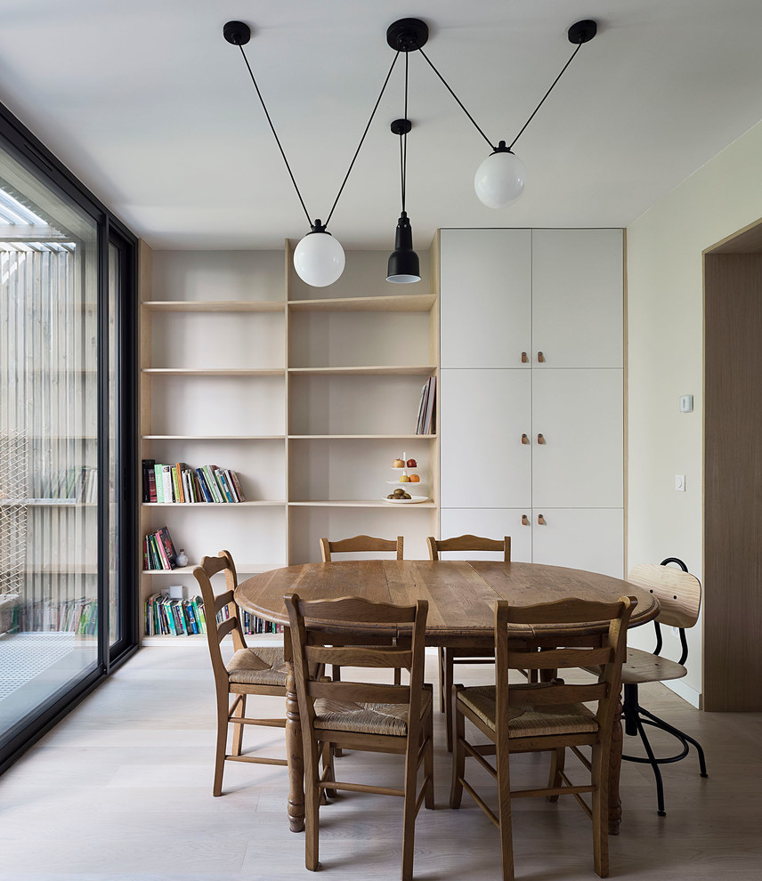 Design ideas for a mid-sized scandinavian open plan dining in Paris with white walls, light hardwood floors and beige floor.