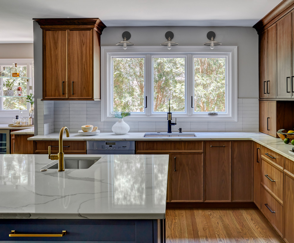 Open concept kitchen - large transitional l-shaped light wood floor and brown floor open concept kitchen idea in Chicago with an undermount sink, flat-panel cabinets, light wood cabinets, quartz countertops, white backsplash, porcelain backsplash, stainless steel appliances, an island and white countertops