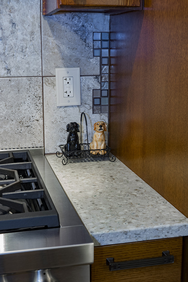 Example of a large arts and crafts u-shaped light wood floor and brown floor enclosed kitchen design with an undermount sink, shaker cabinets, medium tone wood cabinets, quartz countertops, beige backsplash, ceramic backsplash, stainless steel appliances and no island