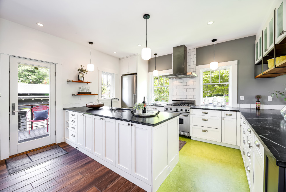 Exempel på ett mellanstort amerikanskt svart svart kök, med en undermonterad diskho, luckor med infälld panel, vita skåp, marmorbänkskiva, vitt stänkskydd, stänkskydd i porslinskakel, rostfria vitvaror, linoleumgolv, en halv köksö och grönt golv