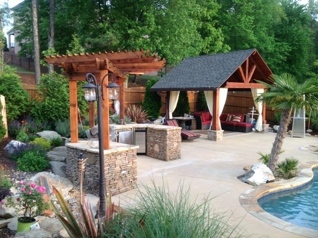 Photo of a large arts and crafts backyard patio in Other with an outdoor kitchen, concrete slab and a gazebo/cabana.