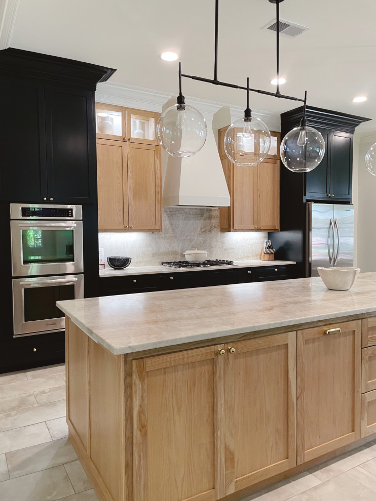 Inspiration for a large transitional galley eat-in kitchen in New Orleans with an undermount sink, shaker cabinets, black cabinets, quartzite benchtops, beige splashback, stone slab splashback, stainless steel appliances, porcelain floors, with island, beige floor and beige benchtop.