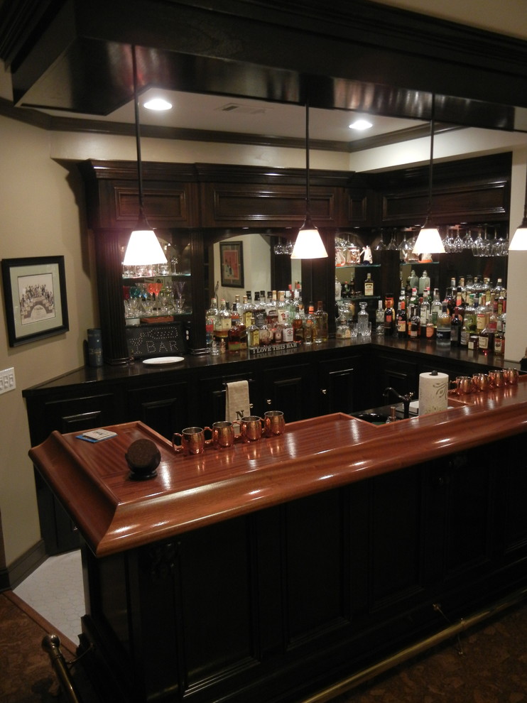 Inspiration for a mid-sized traditional u-shaped wet bar in Atlanta with a drop-in sink, recessed-panel cabinets, dark wood cabinets, wood benchtops, mosaic tile splashback, cork floors, brown floor and brown benchtop.