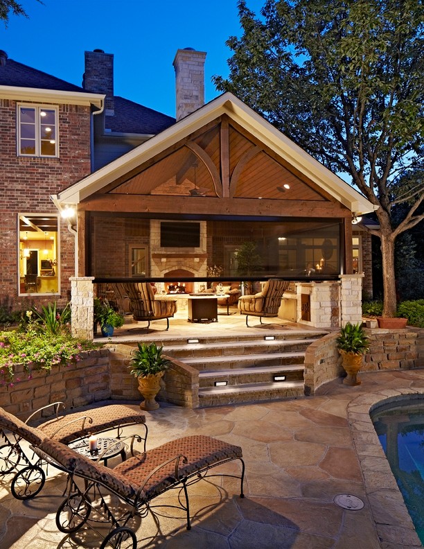 Inspiration for a large traditional backyard patio in Dallas with an outdoor kitchen, a roof extension and natural stone pavers.
